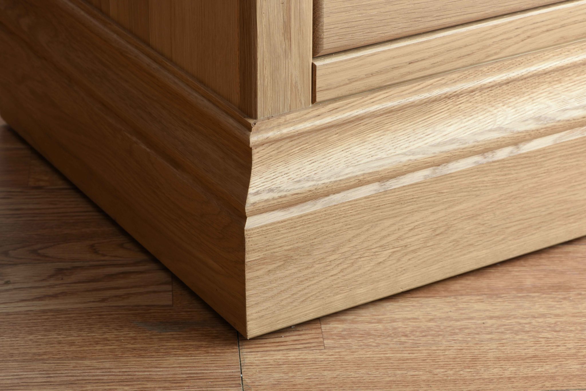 Image of Oak plinth on a oak bedside cabinet, shows the grain and quality of wood and grain. Image showing on Edmunds & Clarke Furniture Blog 