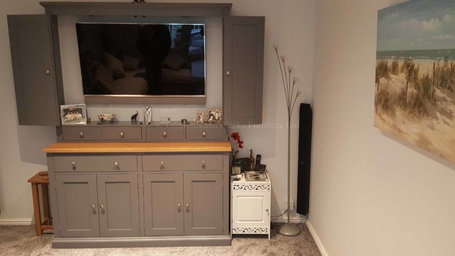 Made to measure tv entertainment cupboard flat screen tv mounted behind bifold doors, deeper cupboard and drawers below, painted in a choice of colours