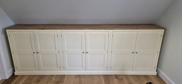 Bespoke 6 Door Low Eave Wardrobe in Holkham sand and solid oak top. Edmunds & Clarke Furniture